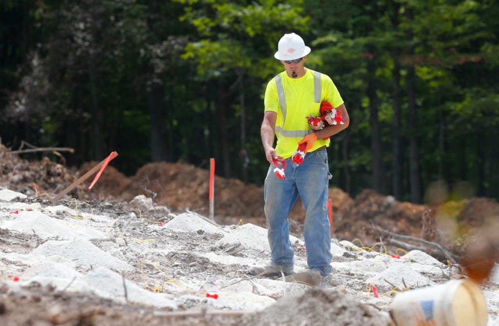 Workers from Austin Powders place charges on the hillside in preparation for blasting (08/23/18)